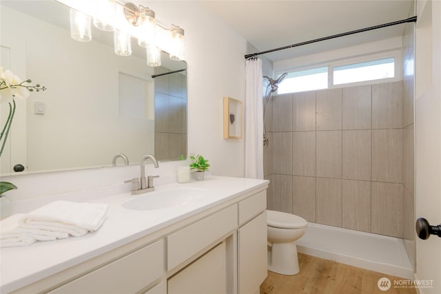 full bath featuring toilet, vanity, wood finished floors, and curtained shower