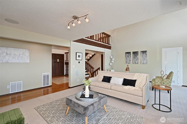 3911 NE 158th Ln, Lake Forest Park, WA 98155 - carpeted living room featuring stairs, a textured ceiling, and wood finished floors