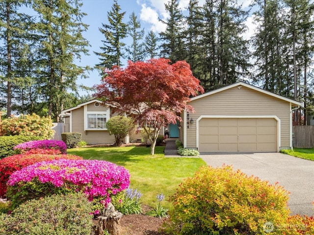 view of property hidden behind natural elements featuring a garage and driveway