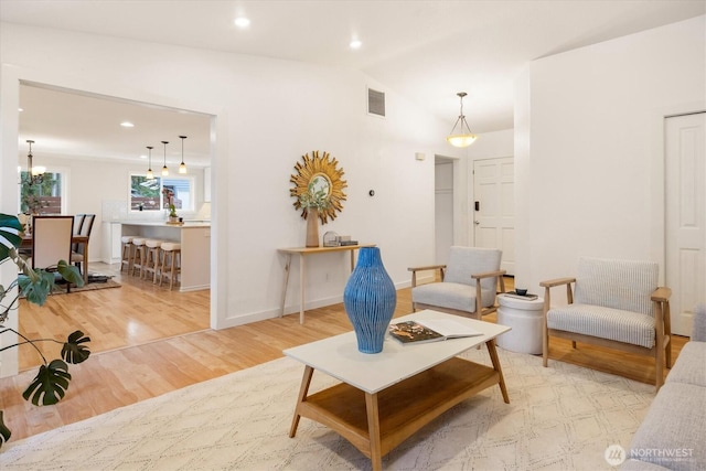 living room with lofted ceiling, wood finished floors, recessed lighting, baseboards, and a chandelier