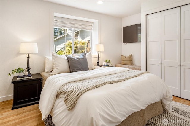 bedroom featuring light wood-style floors, a closet, recessed lighting, and baseboards