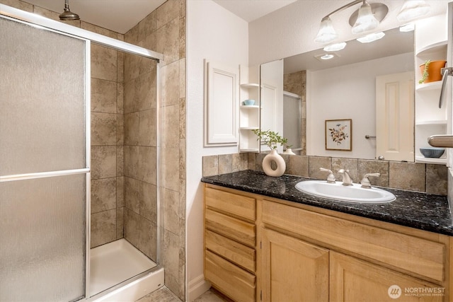 full bath with a stall shower and vanity