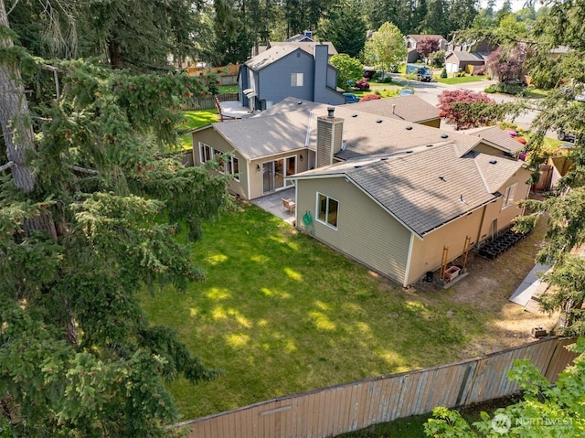 view of subject property with a tree filled landscape