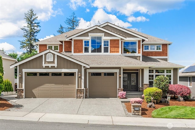 craftsman-style house featuring a shingled roof, stone siding, and driveway