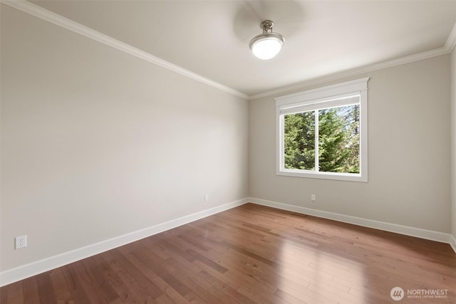 empty room featuring baseboards, crown molding, and wood-type flooring
