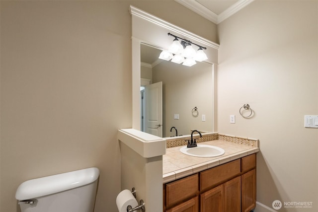 bathroom with toilet, vanity, and ornamental molding
