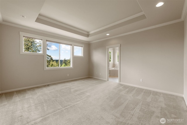 spare room featuring recessed lighting, crown molding, light carpet, a raised ceiling, and baseboards