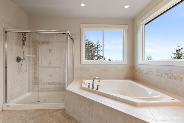 full bathroom featuring a stall shower, a wealth of natural light, and a garden tub