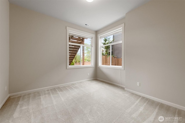 carpeted spare room with visible vents and baseboards