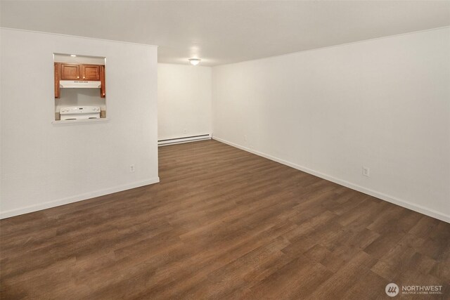 basement featuring baseboard heating, baseboards, and dark wood finished floors