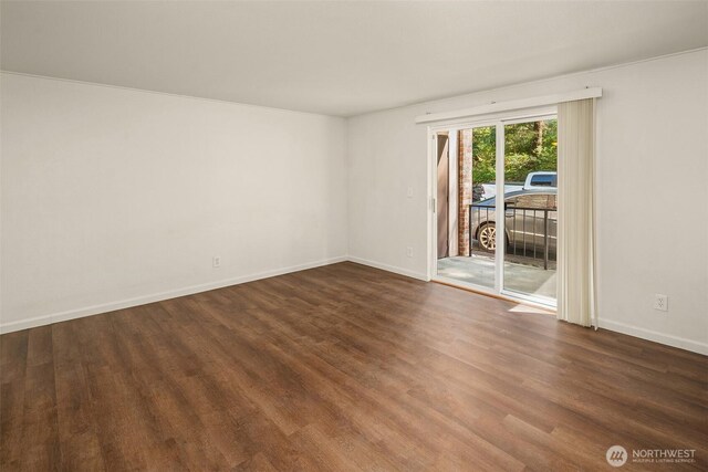spare room featuring wood finished floors and baseboards