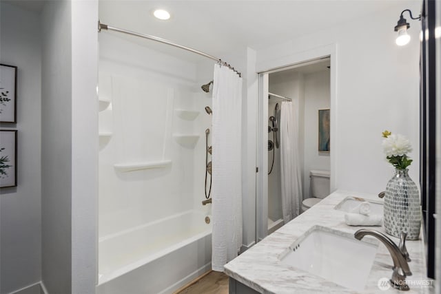 full bath featuring recessed lighting, shower / bath combo, wood finished floors, double vanity, and toilet
