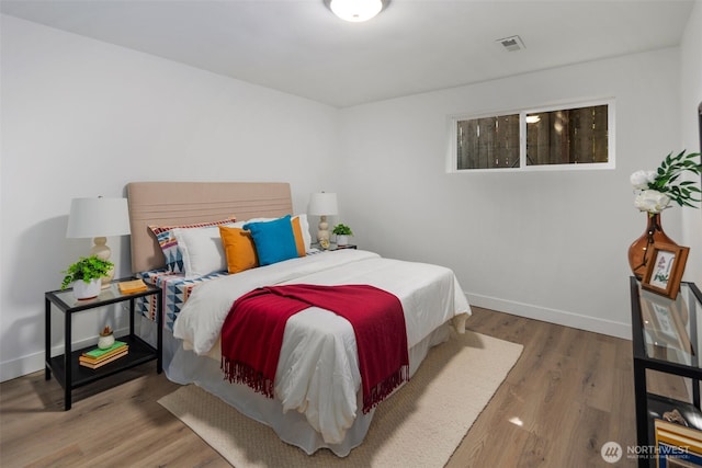 bedroom with baseboards and wood finished floors