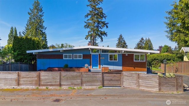 mid-century modern home with a fenced front yard
