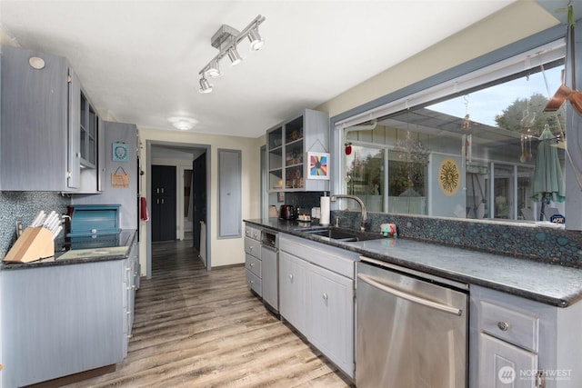 1203 Tower Ave, Raymond, WA 98577 - kitchen with stainless steel dishwasher, a sink, dark countertops, open shelves, and tasteful backsplash