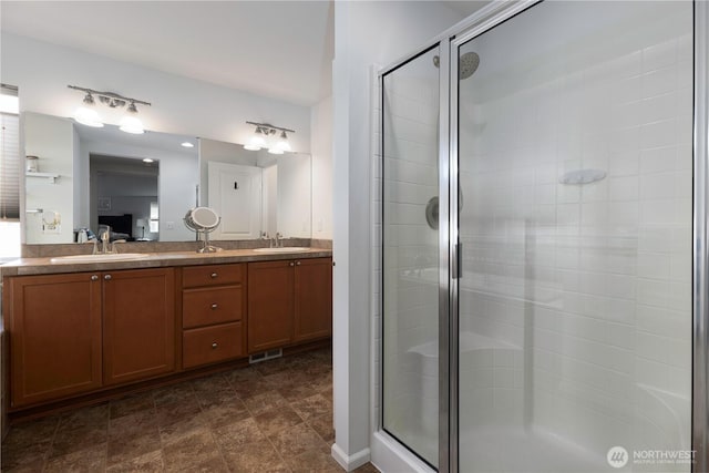 full bathroom with a shower stall and double vanity
