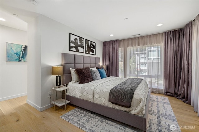 bedroom with baseboards, light wood-type flooring, and recessed lighting
