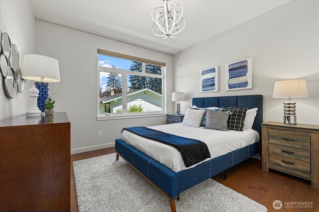 bedroom with wood finished floors, a chandelier, and baseboards
