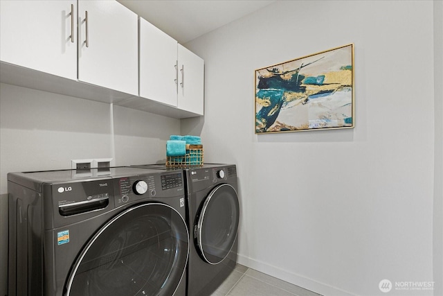laundry room with cabinet space, washing machine and clothes dryer, baseboards, and light tile patterned floors