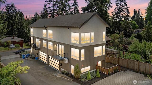 rear view of house with fence and view of scattered trees