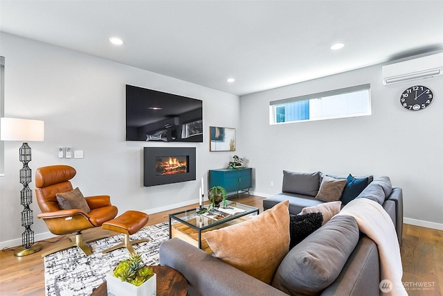 1709 NW 64th St, Seattle, WA 98107 - living room featuring a wall mounted air conditioner, a glass covered fireplace, wood finished floors, baseboards, and recessed lighting