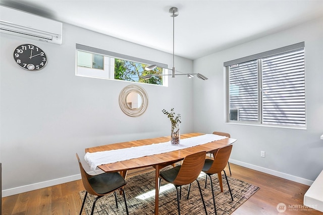 1709 NW 64th St, Seattle, WA 98107 - dining room featuring a wall mounted AC, baseboards, and wood finished floors