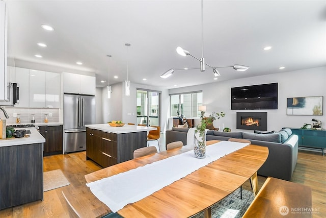 1709 NW 64th St, Seattle, WA 98107 - dining room with recessed lighting, light wood-type flooring, and a glass covered fireplace