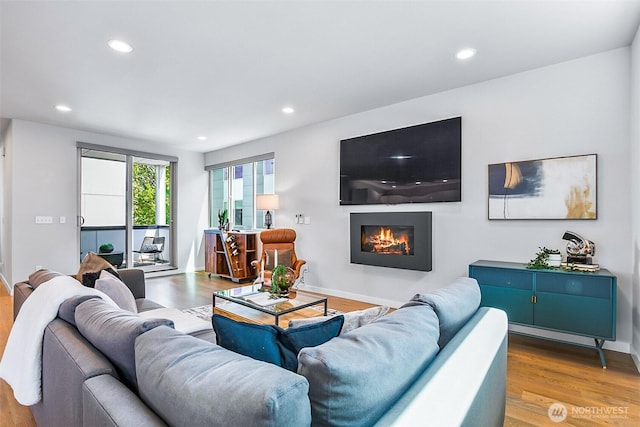 1709 NW 64th St, Seattle, WA 98107 - living room with wood finished floors, a warm lit fireplace, recessed lighting, and baseboards