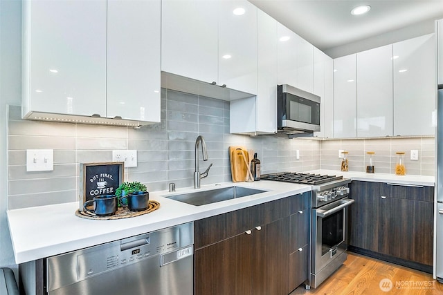 1709 NW 64th St, Seattle, WA 98107 - kitchen featuring appliances with stainless steel finishes, a sink, light countertops, white cabinets, and modern cabinets