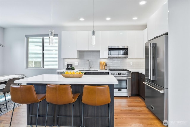 1709 NW 64th St, Seattle, WA 98107 - kitchen featuring high quality appliances, modern cabinets, a sink, a kitchen island, and light countertops