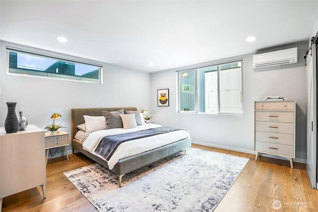 1709 NW 64th St, Seattle, WA 98107 - bedroom featuring a wall mounted AC, light wood finished floors, baseboards, a barn door, and recessed lighting