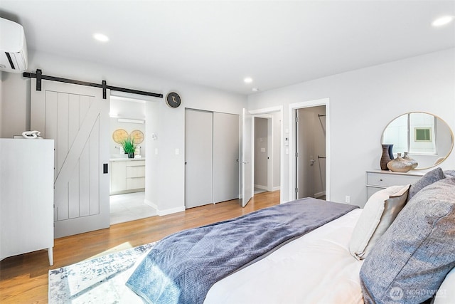 1709 NW 64th St, Seattle, WA 98107 - bedroom featuring a barn door, a wall unit AC, wood finished floors, recessed lighting, and ensuite bathroom