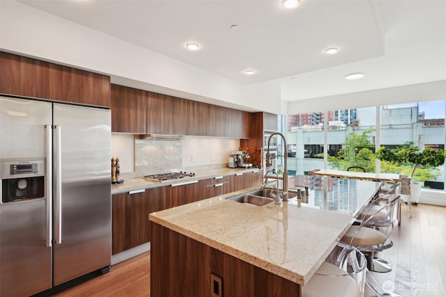1920 4th Ave Unit 502, Seattle, WA 98101 - kitchen featuring stainless steel appliances, a sink, modern cabinets, a breakfast bar, and an island with sink