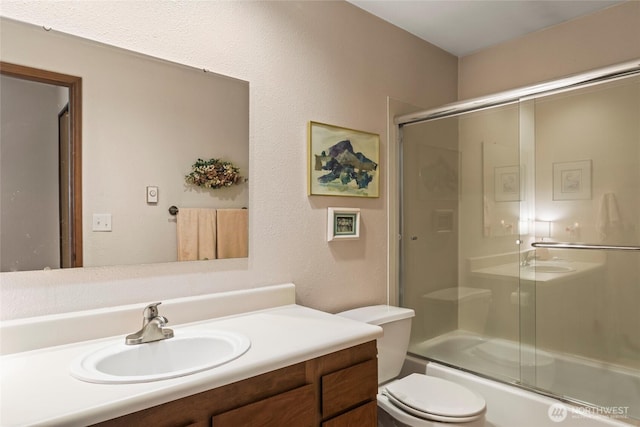 full bath featuring toilet, vanity, and combined bath / shower with glass door