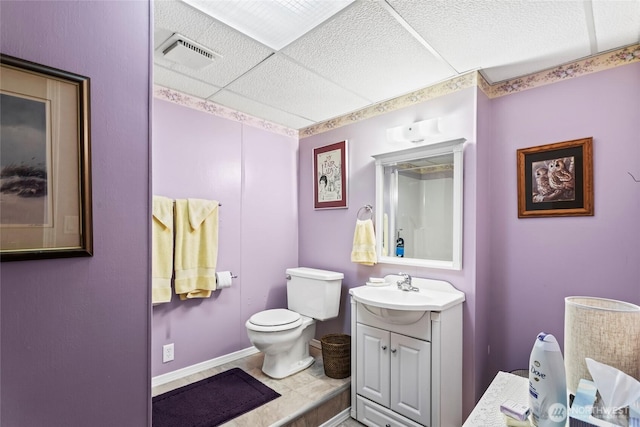 bathroom with toilet, vanity, and baseboards