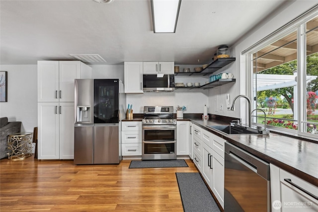 14612 Avon Allen Rd, Mount Vernon, WA 98273 - kitchen with appliances with stainless steel finishes, a sink, dark countertops, white cabinetry, and open shelves