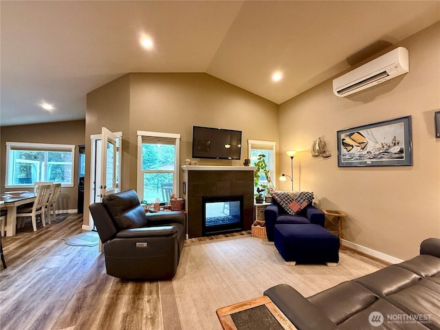 735 Dover Ct SE, Ocean Shores, WA 98569 - living area featuring a wall mounted air conditioner, lofted ceiling, light wood-style flooring, baseboards, and a tiled fireplace