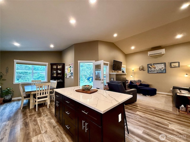 735 Dover Ct SE, Ocean Shores, WA 98569 - kitchen with lofted ceiling, light wood-style floors, baseboards, open floor plan, and a center island