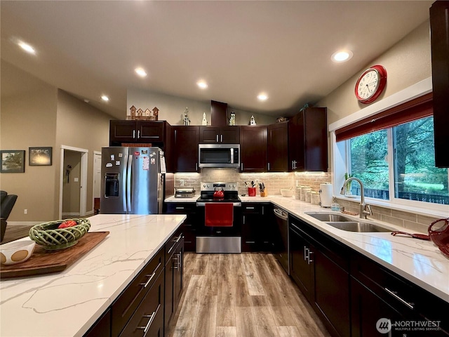 735 Dover Ct SE, Ocean Shores, WA 98569 - kitchen featuring stainless steel appliances, lofted ceiling, light wood-type flooring, light stone countertops, and backsplash