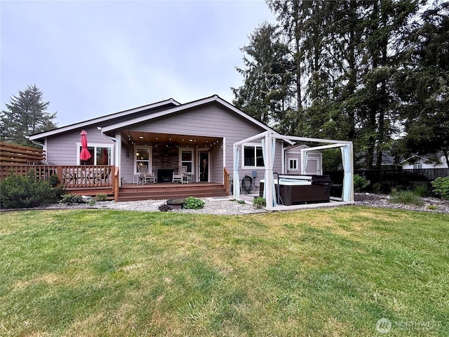 735 Dover Ct SE, Ocean Shores, WA 98569 - back of property featuring a hot tub, a wooden deck, and a lawn