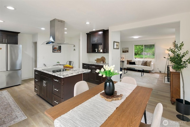 12635 Beacon Ave S, Seattle, WA 98178 - kitchen with freestanding refrigerator, island range hood, black electric stovetop, a center island, and light wood-style floors