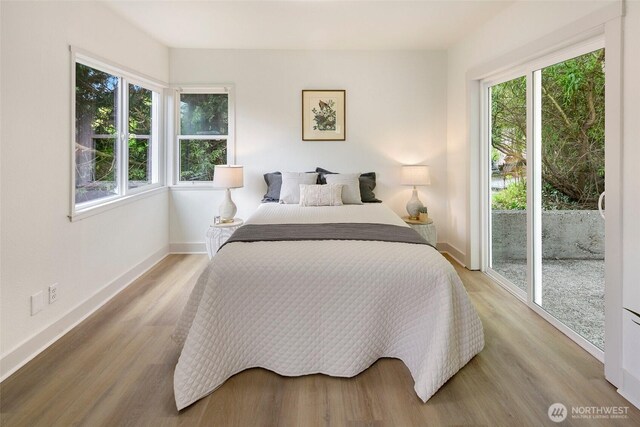 12635 Beacon Ave S, Seattle, WA 98178 - bedroom featuring access to exterior, multiple windows, and light wood-style floors