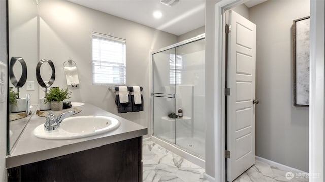 bathroom with double vanity, a sink, baseboards, a shower stall, and marble finish floor