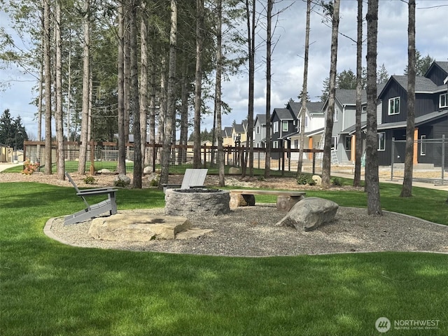 view of community with a yard, fence, and a residential view