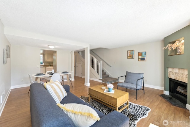 18530 52nd Ave W Unit D2, Lynnwood, WA 98037 - living room featuring stairs, light wood-style floors, baseboards, and a tile fireplace