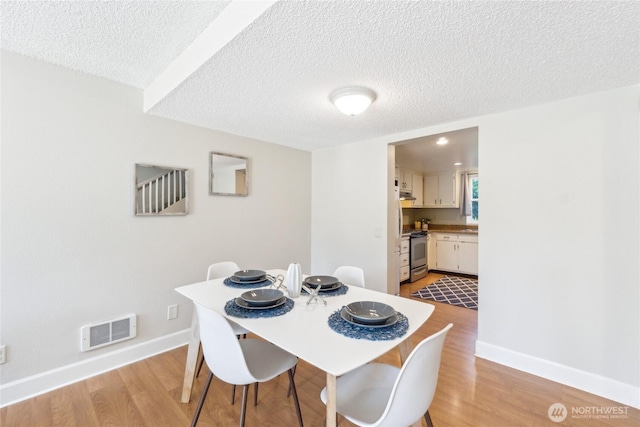 18530 52nd Ave W Unit D2, Lynnwood, WA 98037 - dining area featuring baseboards, light wood-type flooring, and a textured ceiling