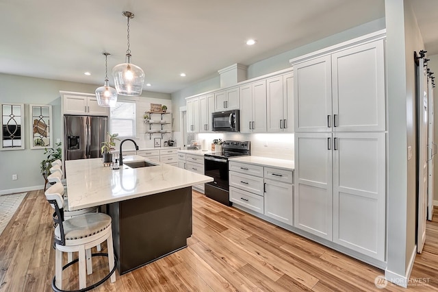 1827 Double Ditch Ct, Lynden, WA 98264 - kitchen featuring black appliances, a sink, white cabinetry, light wood finished floors, and backsplash