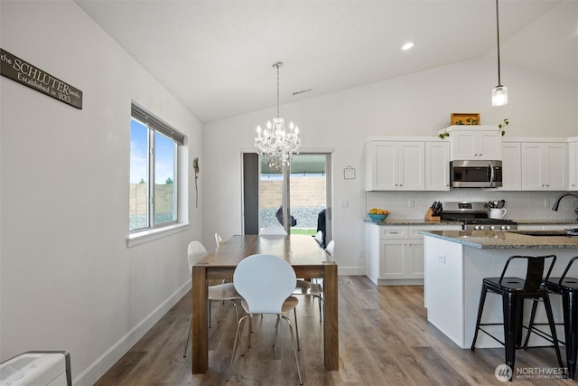 3504 Kathren Ln, Pasco, WA 99301 - kitchen with appliances with stainless steel finishes, a sink, plenty of natural light, white cabinetry, and high vaulted ceiling