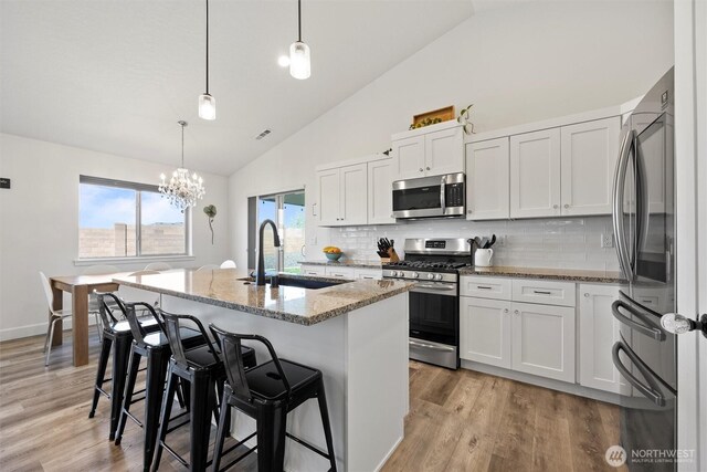 3504 Kathren Ln, Pasco, WA 99301 - kitchen with stainless steel appliances, a sink, light stone countertops, backsplash, and a chandelier