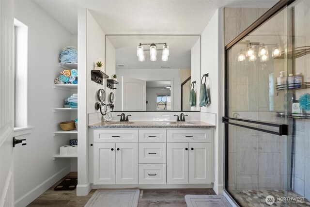 3504 Kathren Ln, Pasco, WA 99301 - full bath featuring a stall shower, double vanity, wood finished floors, and baseboards